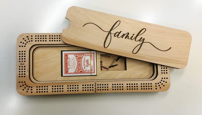 Rectangle shaped Cribbage Board made from wood with the word family on the lid